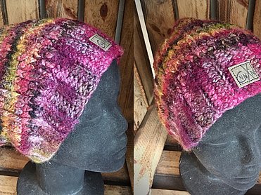 Handgefertigte Beanie-Mütze in kräftigem Pink und Violett mit herbstlichen Akzentstreifen in Senfgelb und Braun.