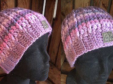  gestreifte Beanie-Mütze in verschiedenen Rosa-, Lila- und Pastelltönen.